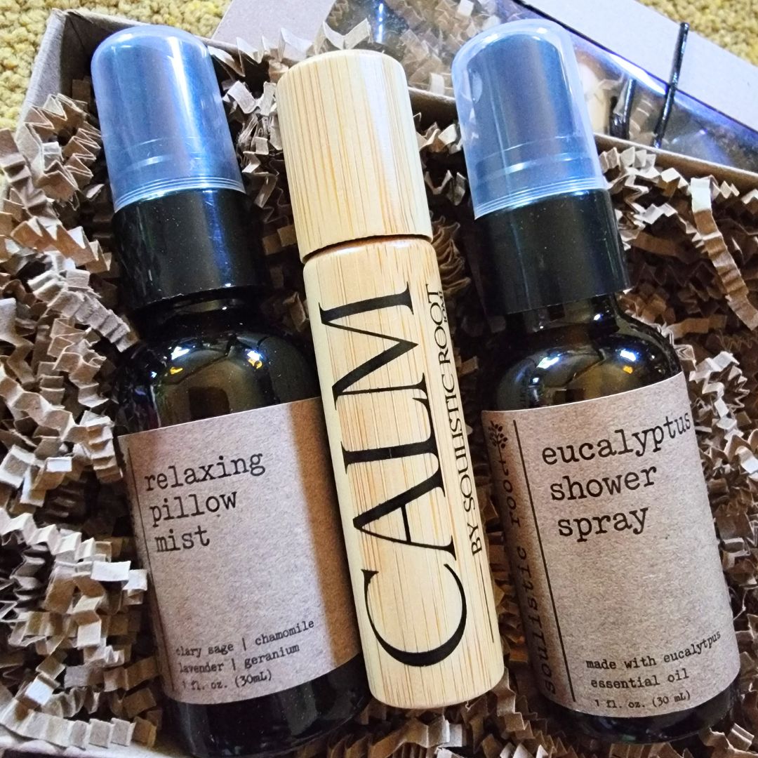 Three spa care and wellness bottles of essential oil products including 'relaxing pillow mist', 'eucalyptus shower spray', and a wooden roller bottle labeled 'CALM'.