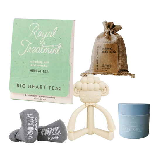 Collection of baby products including a teething toy, tea, bath soap, and balm on a white background.