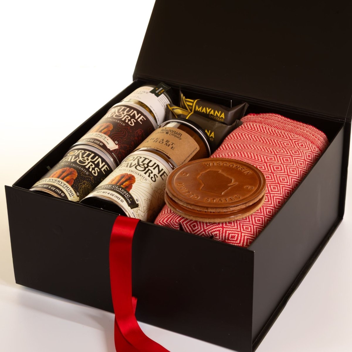 Wisconsin Winter Comfort gift box with red woven blanket, leather Wisconsin coasters, Fortune Favors pecans, Mayana chocolate, and Wisconsin candle