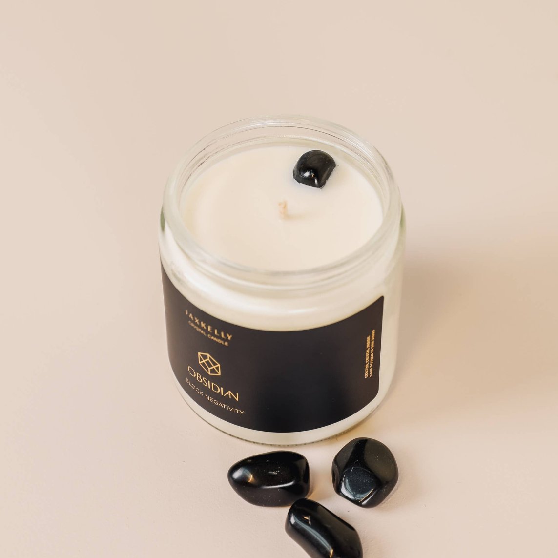 Hand-poured crystal candle with grounding scent and natural Obsidian stone