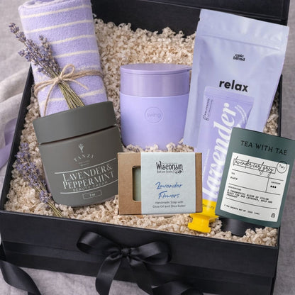 Lavender Spa Gift Box with tea, bath soak, hand cream, soap, face mask, blanket, and  ceramic tumbler. A beautiful Mother’s Day gift and relaxing spa gift for women.