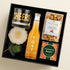 Executive Cheers Gift Box with a Cheers glass, TÖST sparkling tea, caramel popcorn, artisan coaster, and gourmet treats. A modern non-alcohol client appreciation gift.
