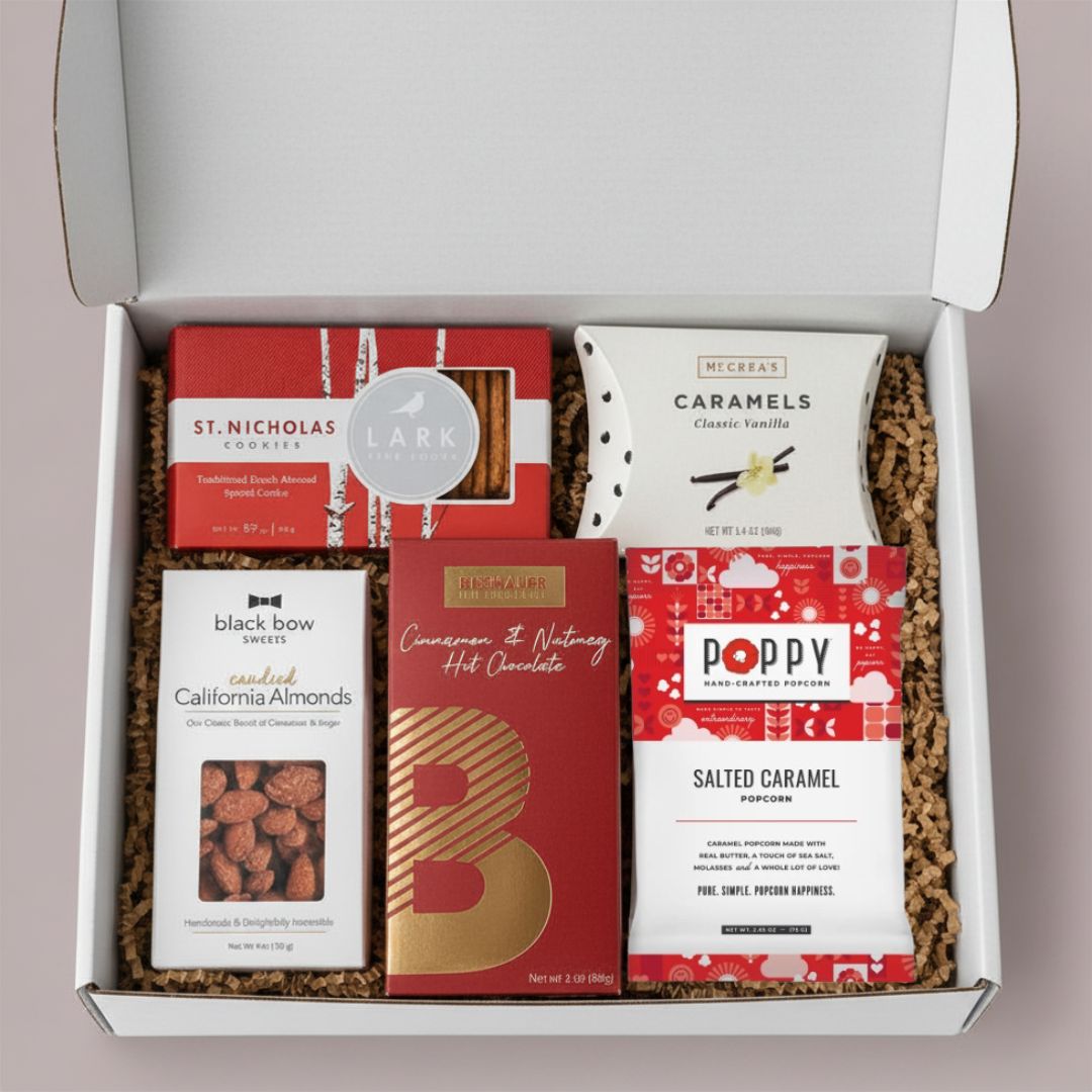  Festive Holiday Treats Gift Box featuring cinnamon hot chocolate, spiced cookies, candied almonds, salted caramel popcorn, and vanilla caramels.