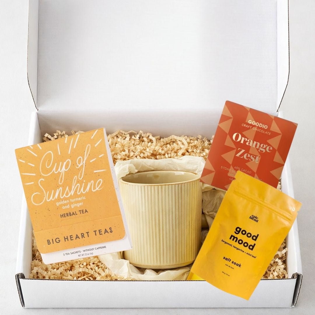 Sending Sunshine Gift Box with coffee mug, bath salt soak, chocolate, and herbal tea in a bright yellow mailer box