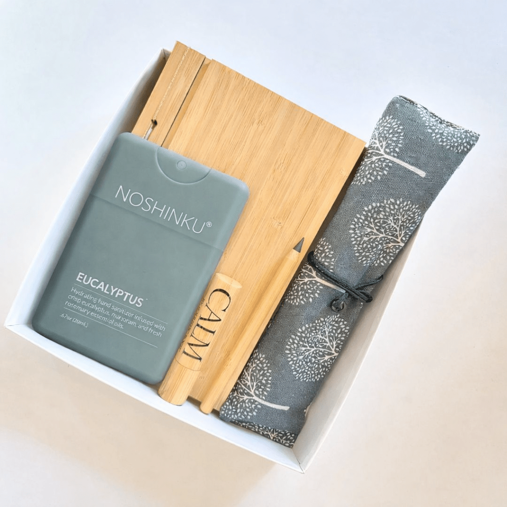 Corporate giveaway gift box with Noshinku eucalyptus sanitizer, bamboo notebook, reusable travel cutlery, calm aromatherapy roll-on, and eco-friendly pencil