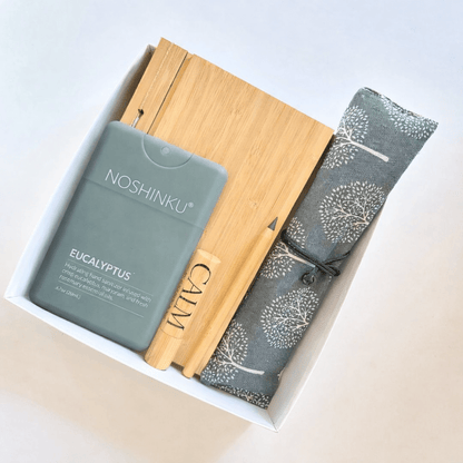 Corporate giveaway gift box with Noshinku eucalyptus sanitizer, bamboo notebook, reusable travel cutlery, calm aromatherapy roll-on, and eco-friendly pencil
